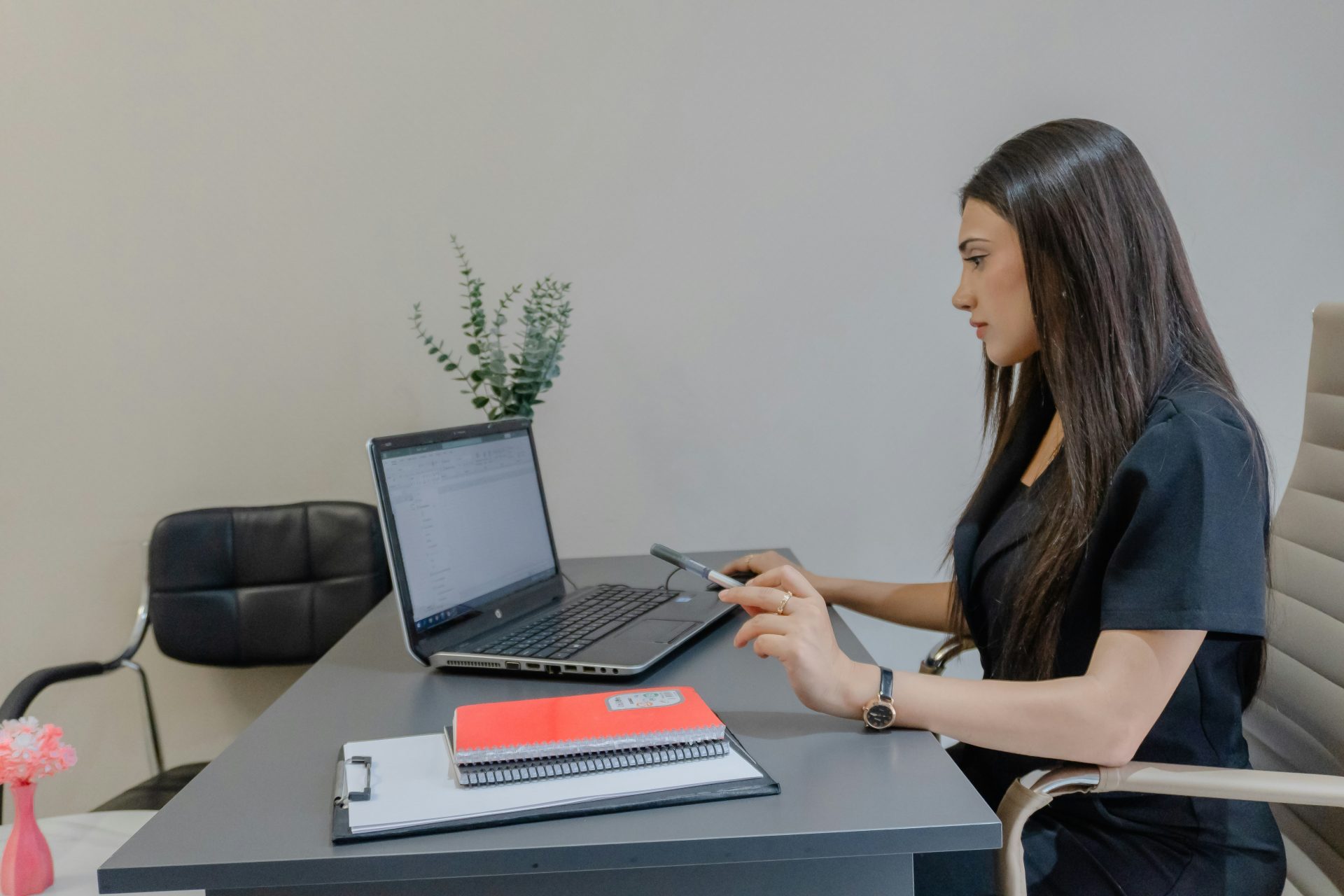 Eine Frau arbeitet an einem Schreibtisch an einem Laptop.